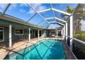 Relaxing screened-in pool area with clear blue water, a patio, and an outdoor dining area at 936 Lassino Ct, Punta Gorda, FL 33950