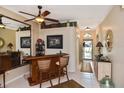 Stylish living area with a mirrored bar, tiled floors, and an arched doorway to the front entrance at 2153 Boxwood St, North Port, FL 34289