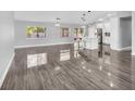 Bright living room featuring glossy floors, neutral paint, and modern lighting, creating an inviting open-concept design at 23227 Adela Ave, Port Charlotte, FL 33952