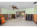 Spacious living room featuring light green walls, ceiling fan, and sliding glass doors to patio at 3000 Wisteria Pl, Punta Gorda, FL 33950
