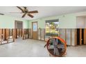 Bright living room with a ceiling fan, a large window, and unfinished walls ready for customization at 3000 Wisteria Pl, Punta Gorda, FL 33950