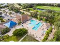 Aerial view of community pool with ample seating, shaded area, and lush landscaping at 14455 Silver Lakes Cir, Port Charlotte, FL 33953