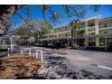 View of condo parking area featuring covered parking, beautiful trees, and well maintained landscaping at 19335 Water Oak Dr # 202, Port Charlotte, FL 33948