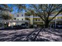Condo parking area featuring covered parking, beautiful trees, and well maintained landscaping at 19335 Water Oak Dr # 202, Port Charlotte, FL 33948