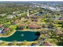 Aerial shot showcasing the condo community with mature trees, lake, and serene surroundings at 19505 Quesada Ave # Ee204, Port Charlotte, FL 33948