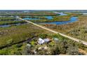 Stunning aerial view of a home nestled among lush vegetation and winding waterways, with a railroad running behind the property at 29175 River Dr, Punta Gorda, FL 33982