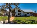 Charming home with a metal roof, lush landscaping, and a welcoming walkway leading to the entrance at 29175 River Dr, Punta Gorda, FL 33982