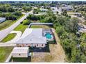 Overhead view of home with screened pool, shed, fenced yard, and metal roof close to a residential road at 4520 Knollwood Dr, Punta Gorda, FL 33982