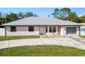 Charming single-story home featuring a metal roof, concrete driveway, and well-maintained front yard at 4520 Knollwood Dr, Punta Gorda, FL 33982