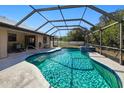 Sparkling in-ground pool inside a screened enclosure, complemented by a spa and patio seating area at 4520 Knollwood Dr, Punta Gorda, FL 33982