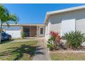 Well-maintained home featuring a screened entrance, attached garage, and tasteful landscaping at 120 Buckeye Nw Ave, Port Charlotte, FL 33952