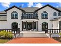 Elegant home exterior showcasing a grand entrance, water feature, and manicured landscaping at 13000 Windcrest Dr, Port Charlotte, FL 33953