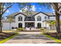 Elegant home exterior showcasing a grand entrance, manicured landscaping, and a circular driveway at 13000 Windcrest Dr, Port Charlotte, FL 33953