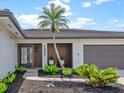 Inviting front entrance with a decorative glass door, lush landscaping, and a modern address display at 1301 Appian Dr, Punta Gorda, FL 33950
