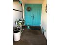 A welcoming blue double door entrance is decorated with plants and a wreath at 21363 Cottonwood Ave, Port Charlotte, FL 33952