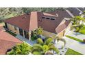 Aerial view of a well-maintained home featuring a newer roof, landscaping and screened-in porch at 8858 Tuscany Isles Dr, Punta Gorda, FL 33950