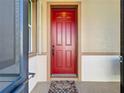 Image shows the front door of the house, painted in a vibrant red color at 8858 Tuscany Isles Dr, Punta Gorda, FL 33950