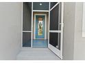 Inviting home entrance featuring a screened porch and a bright blue front door at 122 Glades Dr, Rotonda West, FL 33947