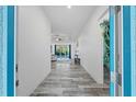 Bright hallway with stylish gray wood-look tile flooring, leading to an open living space at 122 Glades Dr, Rotonda West, FL 33947