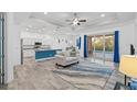 Open-concept living area with a cozy couch, stylish rug, and access to a pool at 122 Glades Dr, Rotonda West, FL 33947