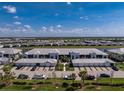 Wide aerial view of the community and condo with garages, showcasing the neighborhood's layout and surroundings near a pond at 14204 Heritage Landing Blvd # 724, Punta Gorda, FL 33955