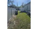 A well-maintained side yard is enclosed with a white vinyl fence at 1594 Hempstead Ave, North Port, FL 34286