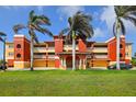 Multi-level condominium building featuring vibrant colors, well-manicured lawns, and mature palm trees at 17495 Boca Vista Rd # 6, Punta Gorda, FL 33955