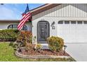 Close up of the home's front entrance, showcasing the arched door and manicured landscaping at 18536 Alphonse Cir, Port Charlotte, FL 33948