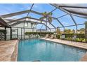 A private screened-in pool with a stone deck and several chairs in the lanai at 18536 Alphonse Cir, Port Charlotte, FL 33948