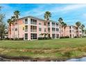 Exterior of condo building featuring multiple screened lanais overlooking a grassy lawn and pond at 2040 Willow Hammock Cir # 208, Punta Gorda, FL 33983