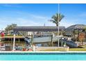 Waterfront boat dock with boat lift and pool in the backyard, offering a relaxing outdoor experience at 21184 Edgewater Dr, Port Charlotte, FL 33952