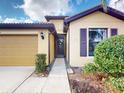 Home exterior featuring warm stucco, tiled roof, and well-maintained landscaping at 2419 Daisy Dr, North Port, FL 34289