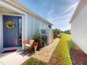 Charming home featuring a welcoming front door with a decorative floral wreath, inviting curb appeal at 24313 Westgate Blvd, Punta Gorda, FL 33980