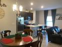 Open-concept kitchen with stainless steel appliances, an island with seating, and stylish lighting fixtures at 244 Surinam St, Punta Gorda, FL 33983