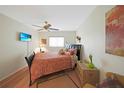 Bright bedroom featuring a decorative headboard, ceiling fan, and a window offering natural light at 25225 Rampart Blvd # 1604, Punta Gorda, FL 33983
