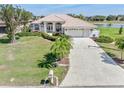 Charming single-story home features a tile roof, manicured lawn, and a long driveway leading to an attached two-car garage at 26373 Madagascar, Punta Gorda, FL 33983