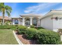Inviting front entrance showcases lush landscaping, a fountain, and arched windows, enhancing the home's curb appeal at 26373 Madagascar, Punta Gorda, FL 33983