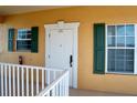 Exterior view of front door with green shutters, a white door, and a ramp at 3216 Purple Martin Dr # 121, Punta Gorda, FL 33950
