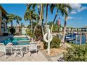 Backyard pool view with lounge chairs, palm trees, and a dock on the water at 3216 Purple Martin Dr # 121, Punta Gorda, FL 33950