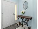 Inviting foyer with a decorative table, a patterned rug, and a stylish oval mirror at 3748 Albacete Cir # 38, Punta Gorda, FL 33950