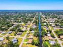 Aerial view of a home with a canal running through the neighborhood, surrounded by lush greenery at 429 Dorchester St, Port Charlotte, FL 33954