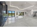 Open-concept living space with ceiling fan, a black marble fireplace wall, and views of the backyard at 7363 N Moss Rose, Punta Gorda, FL 33955