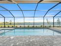 Screened-in pool overlooks a tranquil lake at 8604 Shore Lake Dr, Englewood, FL 34224