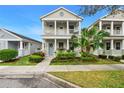 Charming two-story home featuring a welcoming front porch and beautifully landscaped yard at 12492 Shimmering Oak Cir, Venice, FL 34293