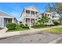 Charming two-story home with a quaint front porch and beautiful landscaped yard viewed from the street at 12492 Shimmering Oak Cir, Venice, FL 34293