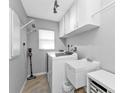 Efficient laundry room with a washer, dryer, sink, and ample cabinet storage at 1303 Casey Key Dr, Punta Gorda, FL 33950