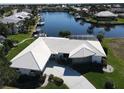 Expansive aerial shot showcases the waterfront property with boat dock, waterway access, and well-manicured lawn at 1407 Waxwing Ct, Punta Gorda, FL 33950