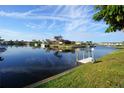 Scenic waterfront view with calm water, docks, boats, and lush landscaping in a tropical setting at 1407 Waxwing Ct, Punta Gorda, FL 33950