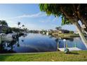 Serene waterfront view showcasing calm waters, multiple boats, and dockside amenities surrounded by palm trees at 1407 Waxwing Ct, Punta Gorda, FL 33950