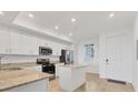 Bright kitchen featuring stainless steel appliances, granite countertops, and a convenient center island at 14071 Heritage Landing Blvd # 325, Punta Gorda, FL 33955